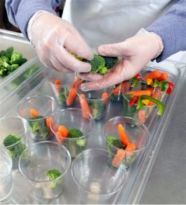 Placing vegetables in cups for individual serving